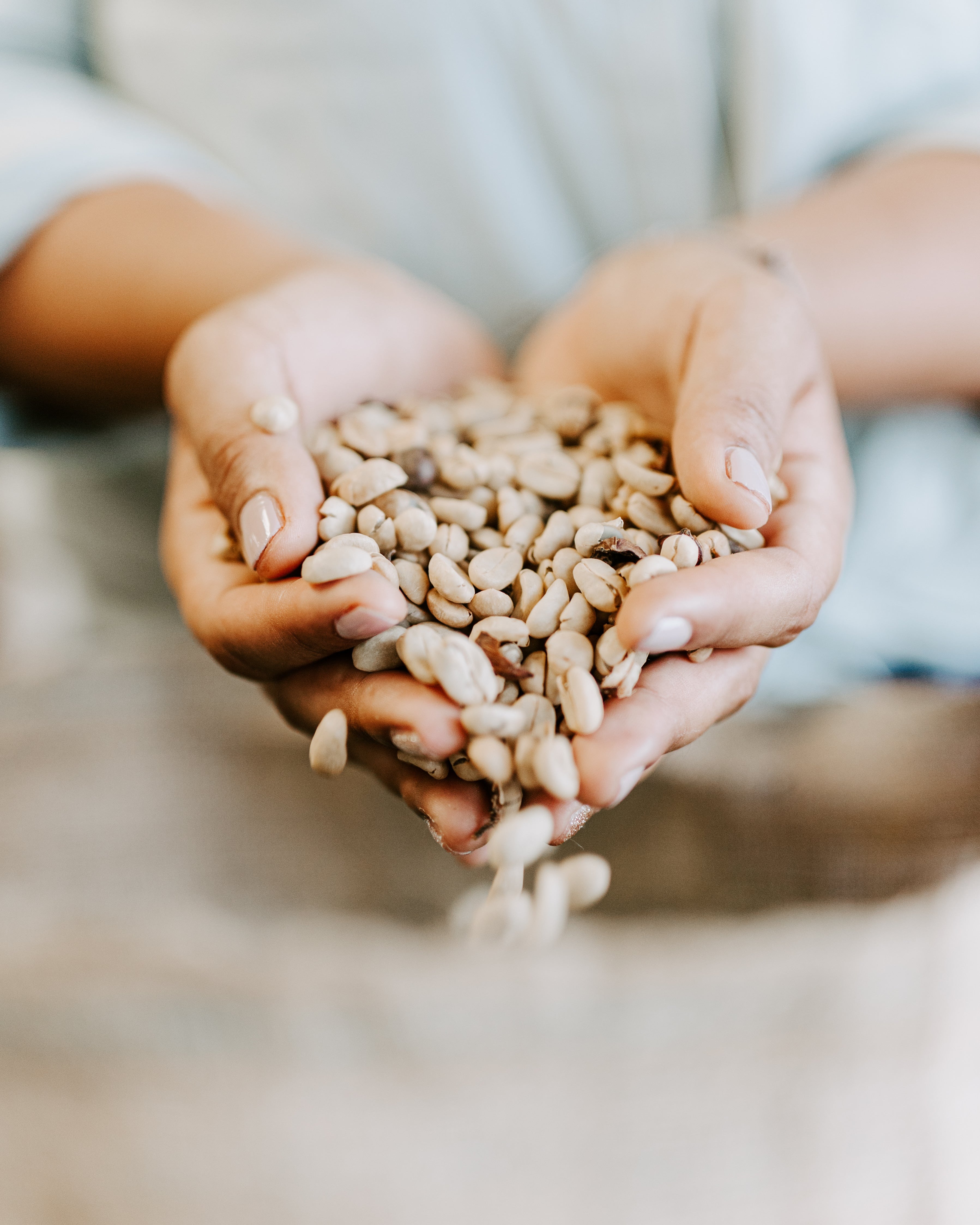 Victoria holding roasted coffee beans from Misma Lani, showcasing our 100% Kona coffee and the care behind every batch.